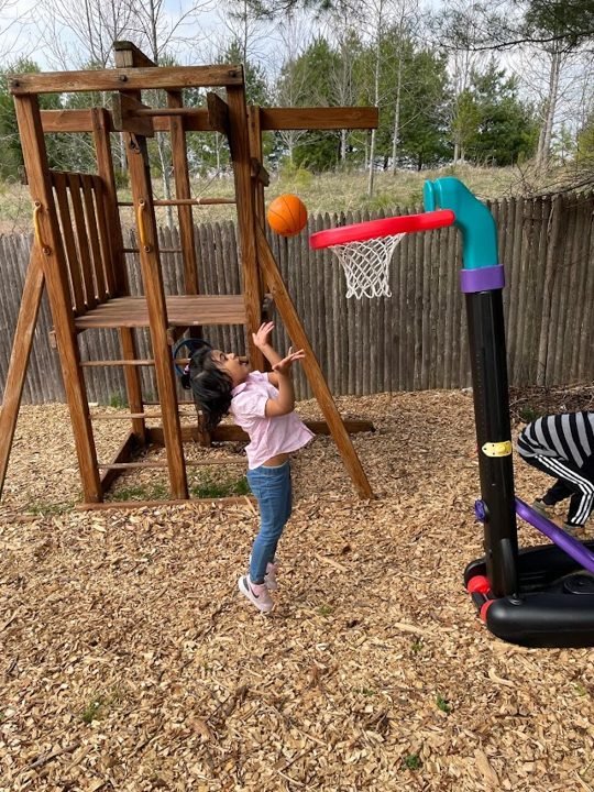 A child playing basketball on a playground