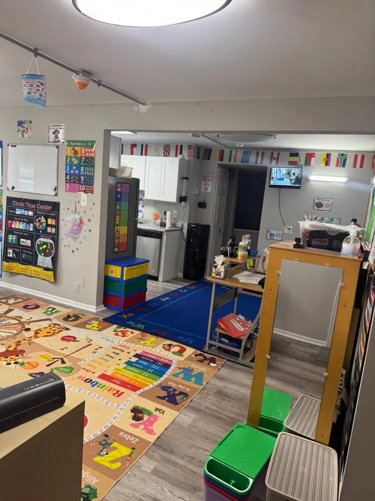 EduCastle classroom with an alphabet rug, circle time chart, colorful storage bins and world flags along the ceiling