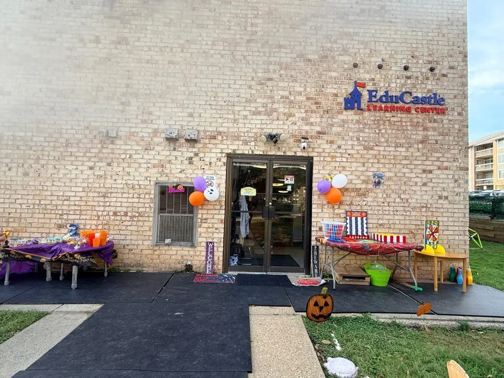 The EduCastle Learning Center entrance decorated with balloons, a jack-o&rsquo;-lantern and carnival game tables for the Halloween fall festival