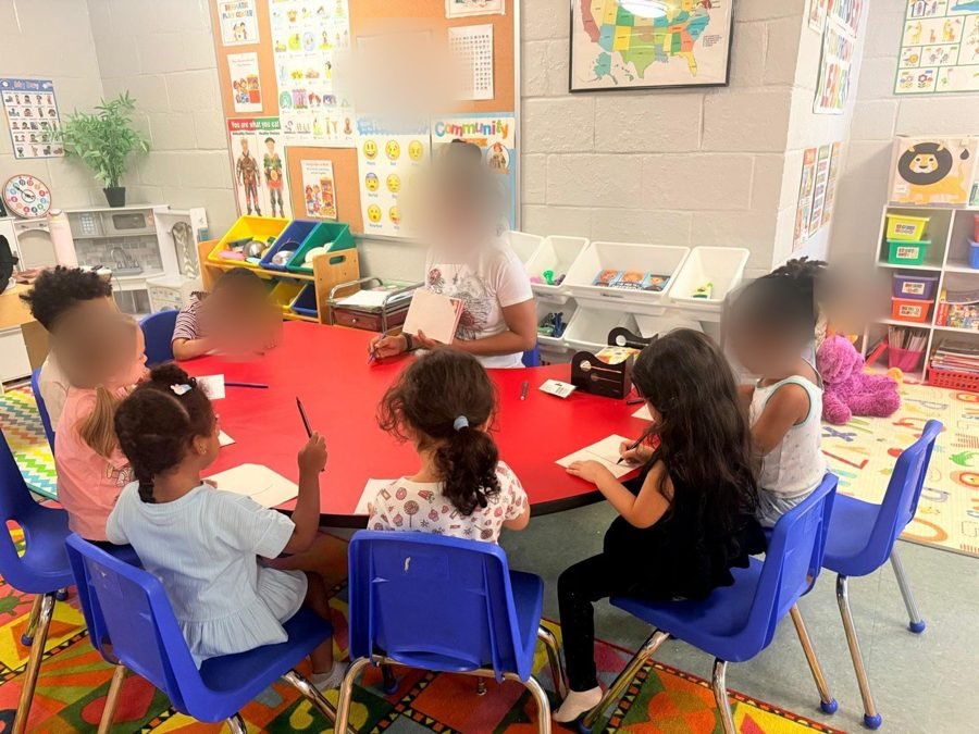 Writing practice at the round table at EduCastle Learning Center, faces blurred for privacy