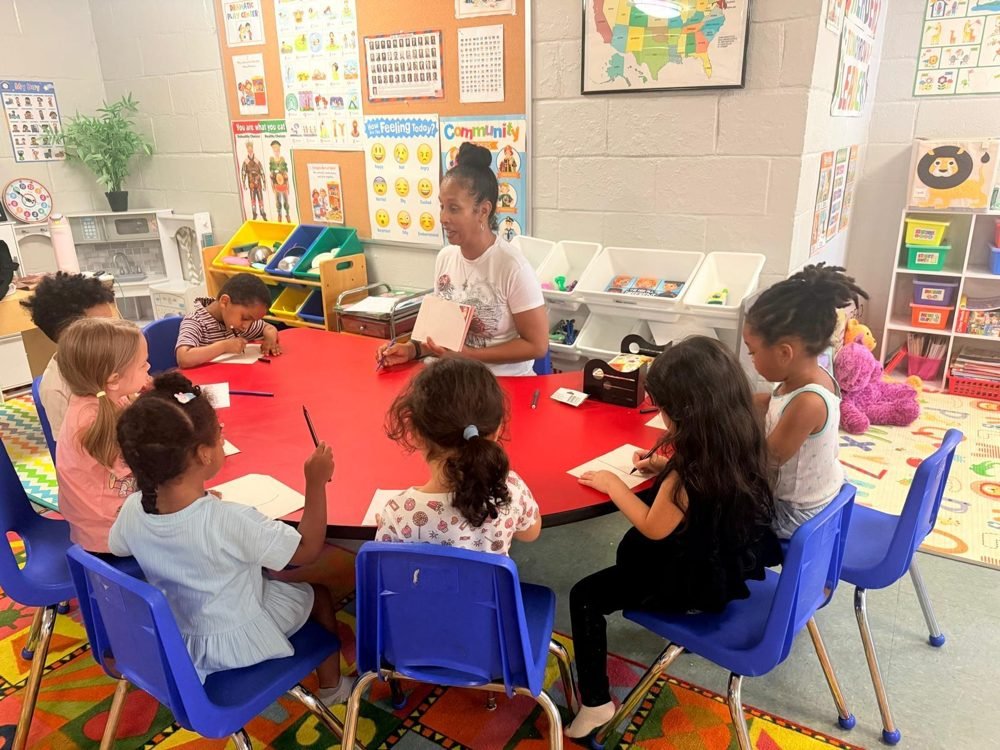 Ms. Trina leading writing practice at the round table