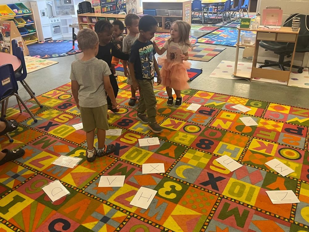 Children playing a letter-matching game on the alphabet rug